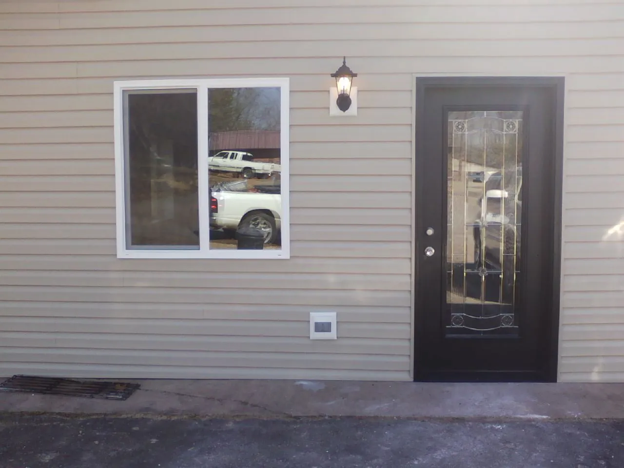 New siding, window and entry door on the side of an addition in Vilas
