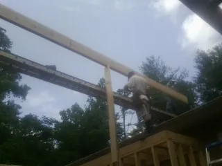 Carpenter setting a ridge beam over a new addition frame — Ice Dam Removal by Roofing Brothers in Vilas