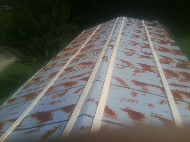 Rusted metal roof panels with new wood purlins before replacement — Storm Damage Roof Repair in Vilas by Roofing Brothers